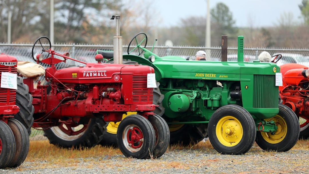 Historische Traktoren von Farmall und John Deere bei einer Auktion für Landtechnik.