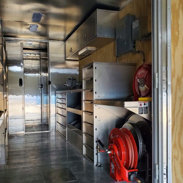 Professionell ausgebauter Laderaum eines Transporters mit Metallregalen und Werkstattausrüstung.