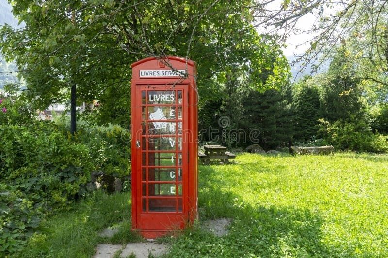 Roter öffentlicher Bücherschrank in einer grünen Gartenanlage